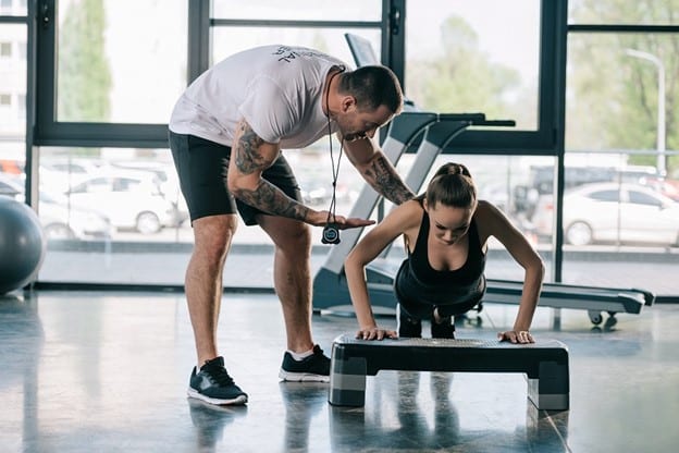 Image of a personal trainer working with a client on the National Personal Training Institute website