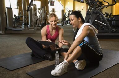 Image of a woman working with a personal trainer in a gym