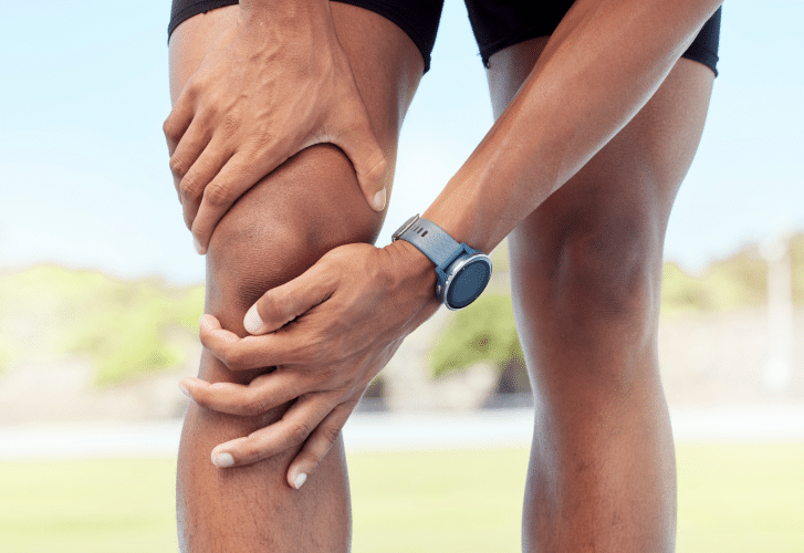 Image of an athlete holding their knee