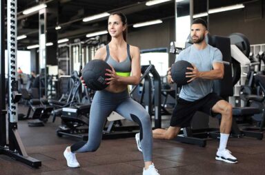 Attractive couple doing fitness with medcine ball at gym