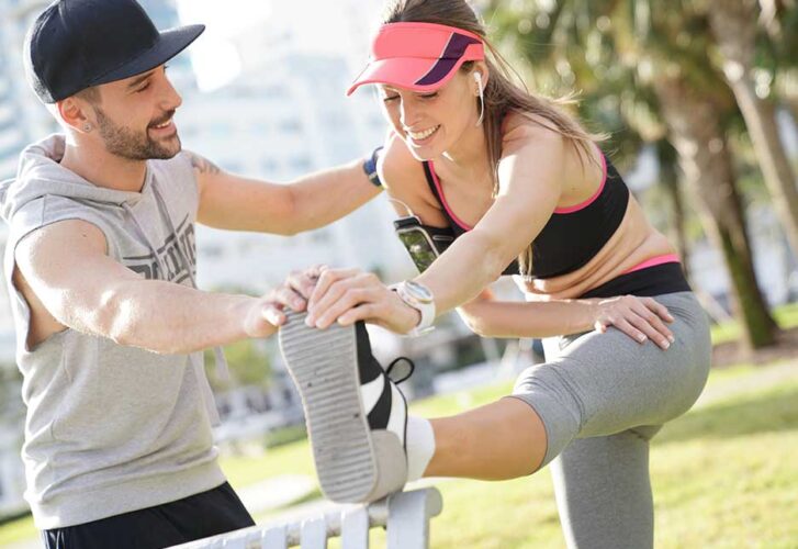 Fitness girl with coach exercising at the park