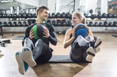 Fit couple doing abdominal exercise with fitness balls