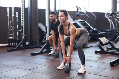 Fit and muscular couple focused on lifting a dumbbell