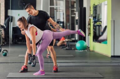 Young woman with personal trainer in the gym