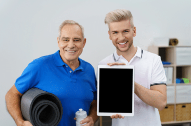 Fit proud elderly man with his personal trainer