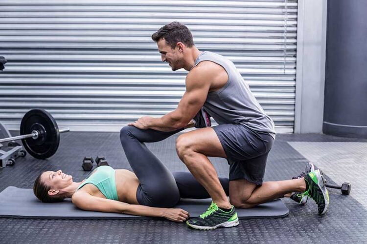 Muscular couple doing a leg stretching