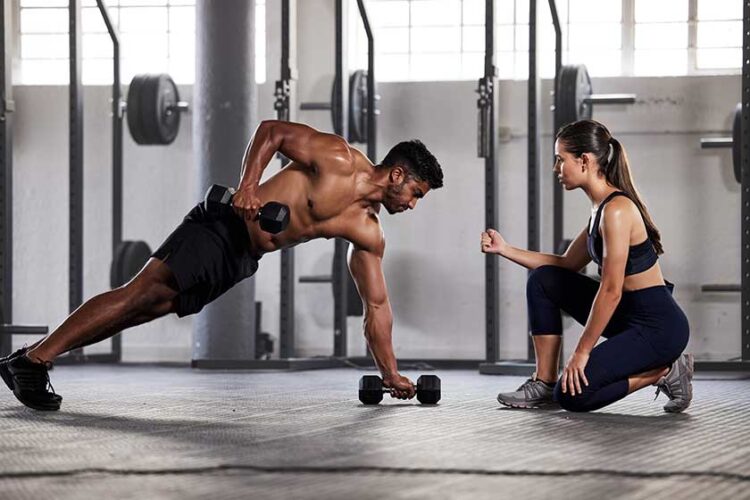 Muscular, sports man with female gym instructor