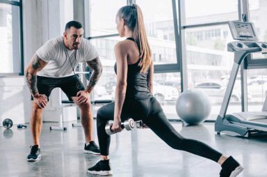 Male personal trainer looking at sportswoman