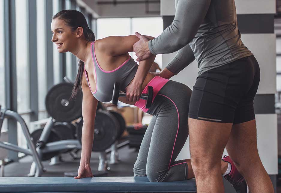 Attractive young woman working out with dumbbells