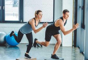 Man and woman having cross training in gym