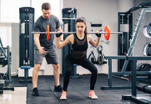 Young beautiful woman doing exercises with personal trainer